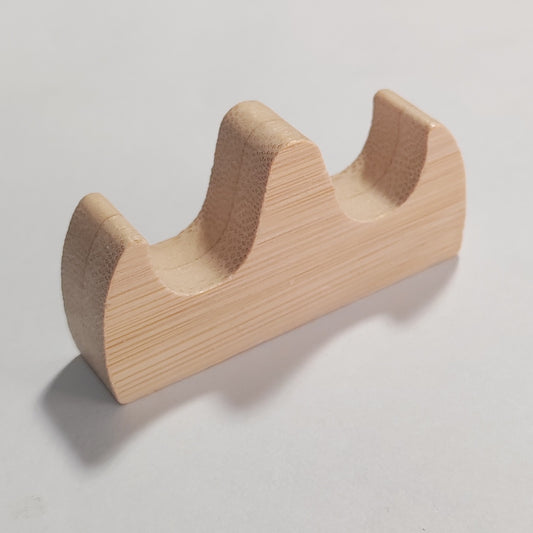A light natural wood two-tier tool display stand with a visible wood grain texture, photographed on a neutral light grey background.