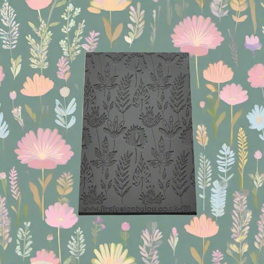A 95 x 55 mm debossed texture mat with a flower design. Use to make a embossed impression on metal clay and polymer clay.